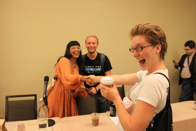 Photo of Isha joyfully greeting conference attendee