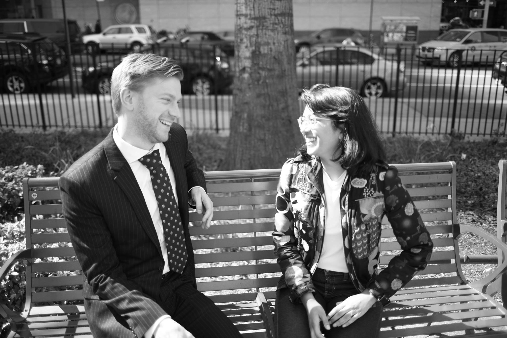 Dan and Isha talking while sitting on a bench